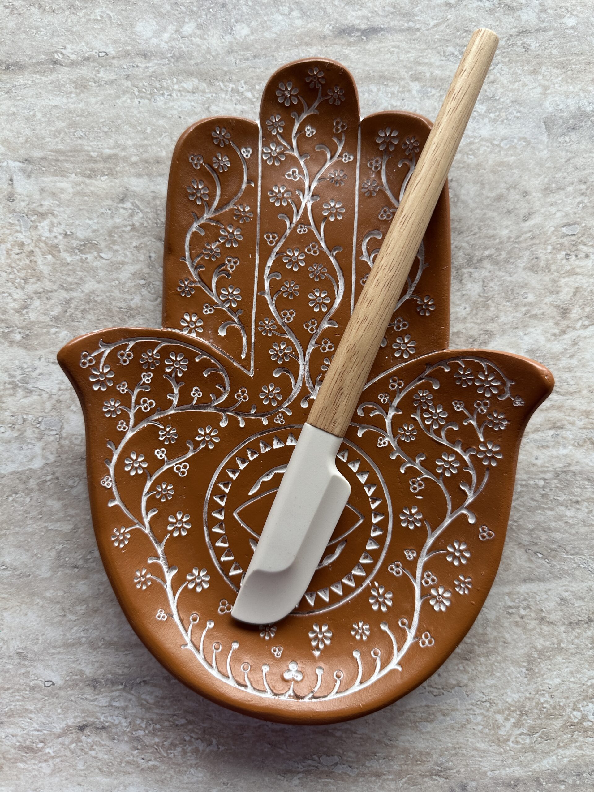 kleine henna spatula op een schaal in de vorm van een hand van fatima