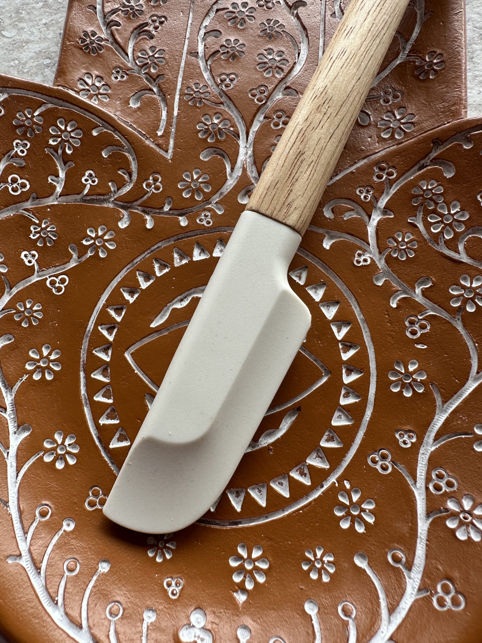 henna roer spatel op een bord met henna patronen